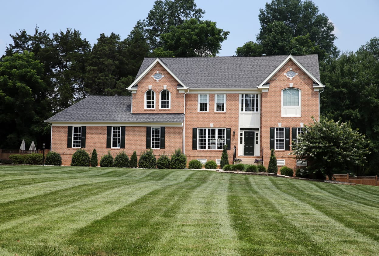 Brick colonial home with a wide lawn, managed as a long-term rental